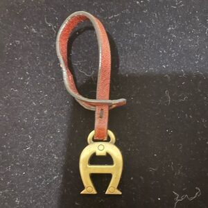 Brass ‘A’ bag charm on leather leash Entienne Aigner
